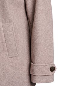 Light brown wool coat sleeve with a subtle texture, featuring a single button at the cuff and a square pocket.
