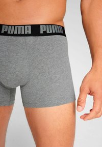 Gray cotton boxer shorts with a black waistband featuring the "PUMA" logo in light gray, snug fit, and smooth texture.