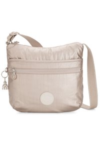 Beige nylon crossbody bag with a textured surface, featuring a front zipper pocket, logo patch, and a decorative charm. Adjustable strap.