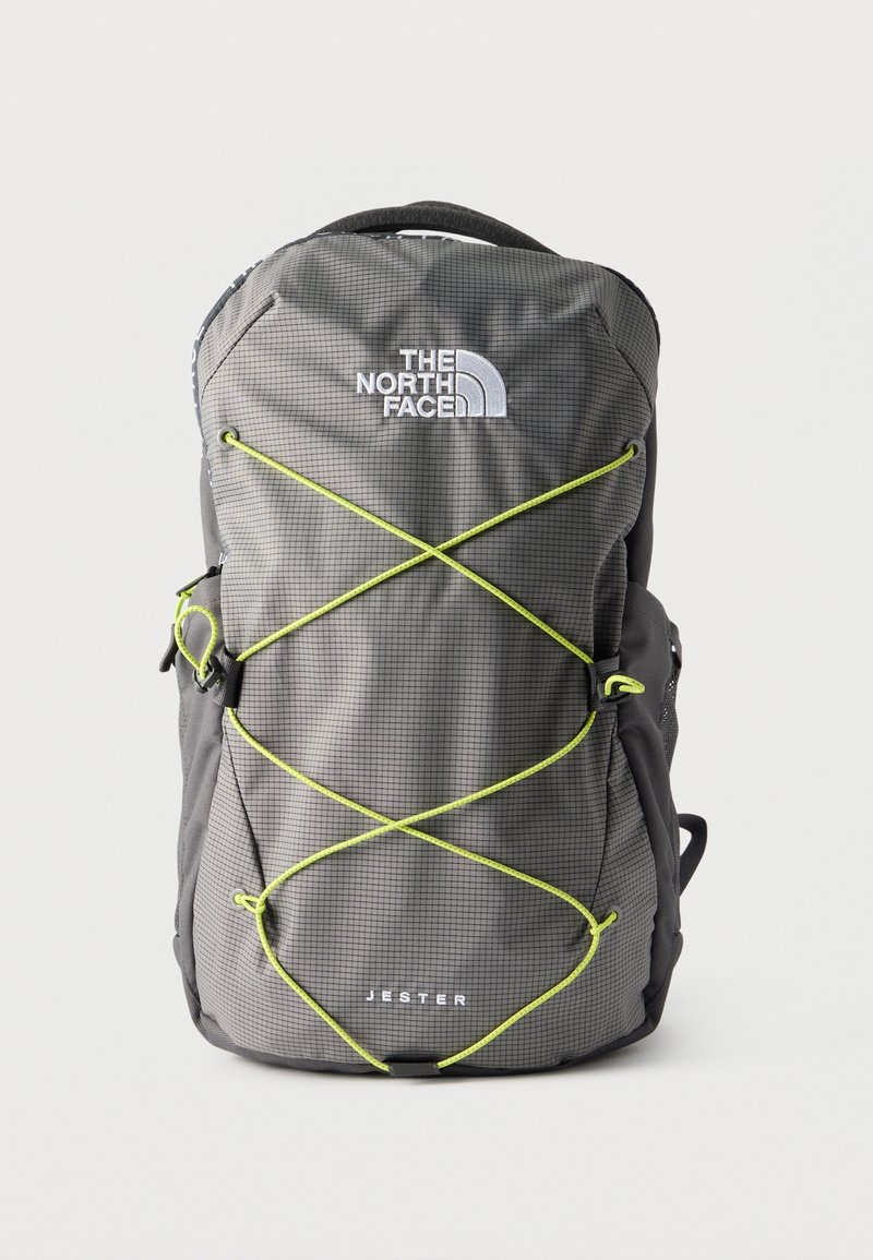 Γκρι σακίδιο πλάτης The North Face Jester με φωτεινούς πράσινους ιμάντες ελαστικούς και πάνω χειρολαβή, εμφανίζεται από μπροστά σε λευκό φόντο.