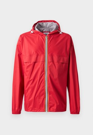 Rode windjack met capuchon, rits aan de voorkant en elastische manchetten. Voorzien van twee bovenste borstzakken en een contrasterende gestreepte rits. Licht materiaal.