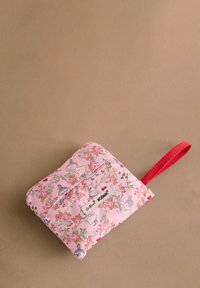 Quiltowany różowy materiałowy woreczek z kwiatowymi wzorami i ilustracjami Muminków. Posiada czerwoną tkaninową rączkę oraz przednią klapkę z etykietą.