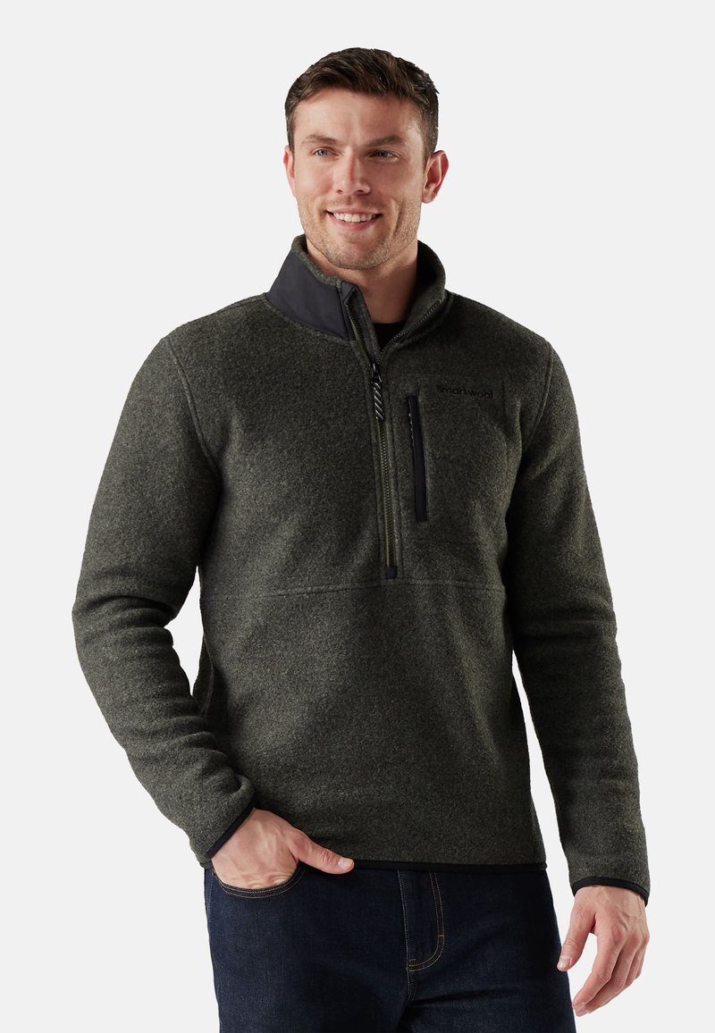 Pullover in pile verde scuro con colletto a mezza zip e accenti neri. Presenta una tasca sul petto e un tessuto testurizzato per il calore.