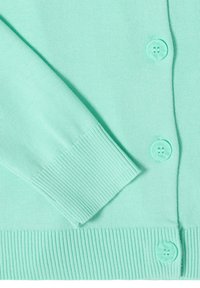 Manche d'un cardigan tricoté turquoise clair avec un devant boutonné, bordures côtelées aux poignets et à l'ourlet en gros plan.