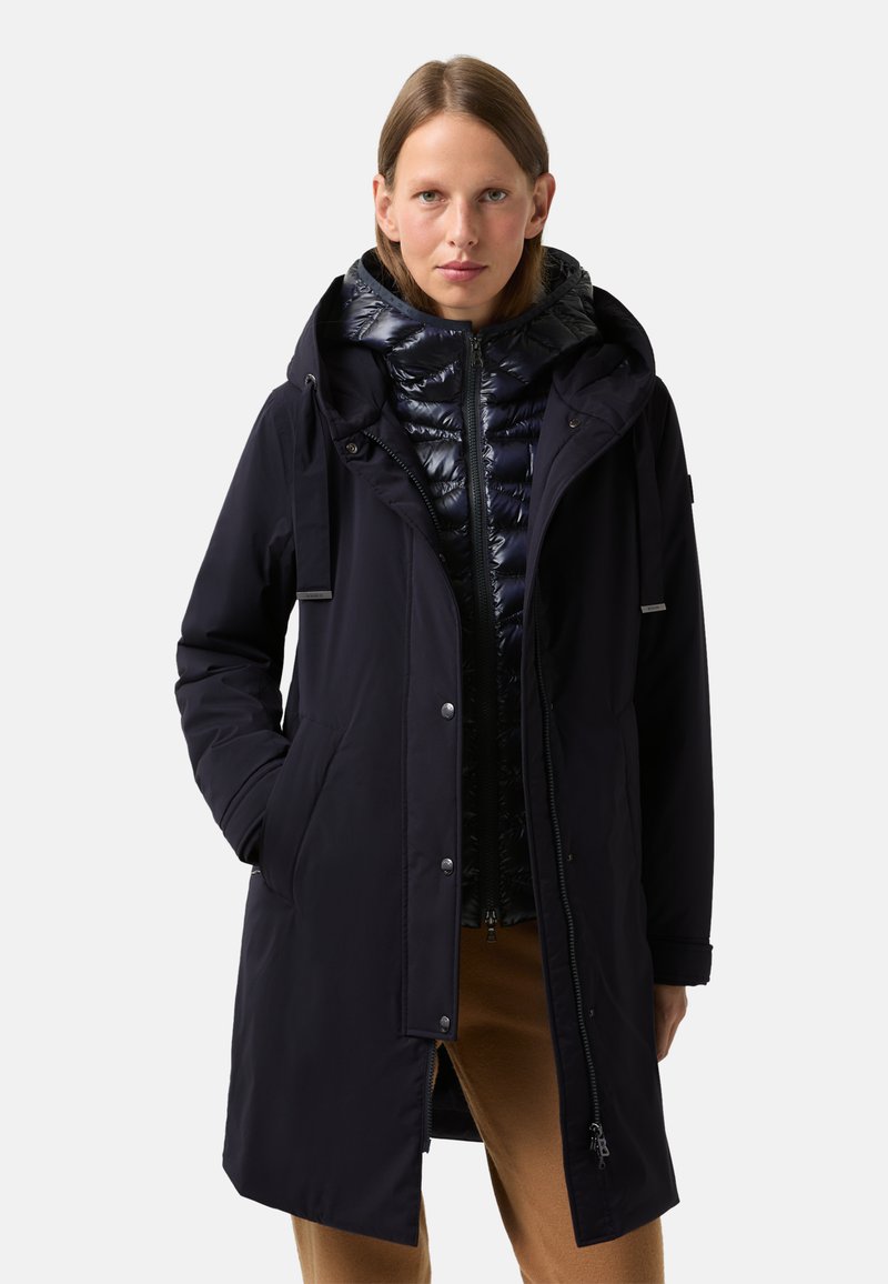 Granatowy wodoodporny parka z zamkiem błyskawicznym, kapturem i wewnętrzną warstwą puchową. Posiada boczne kieszenie, luźny krój i gładką teksturę.