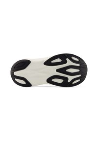 Zwarte en witte zool van een sportschoen met gestructureerd zwart rubber en witte ondersteuningszones, met een dynamisch, gevormd ontwerp.