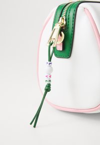 Piccola borsa bianca con accenti verdi e rosa, dotata di una cerniera dorata e di un pon-pon in pelle decorato con perline colorate che formano la parola "AMORE."