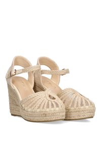 Sandalias de cuña beige con parte superior de cuerda trenzada, punta abierta, tira en el tobillo y forro de tela estampada. Plataforma de yute elevada con superficie texturizada.