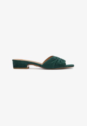 Mules en daim vert avec un petit talon carré, présentant un design avant drapé et une doublure intérieure lisse, offrant une silhouette simple et élégante.
