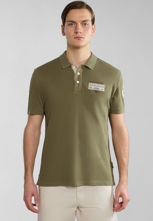 Polo shirt à manches courtes en coton olive, avec un col beige, un patch logo sur la poitrine et des fentes sur les côtés pour plus de liberté de mouvement.