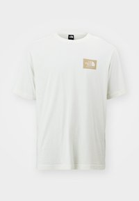 Vit t-shirt i bomull med korta ärmar, med en liten logopatch i beige på vänster bröst. Slät textur och klassisk rundad halsdesign.