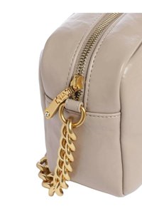 Borsa in ecopelle color crema con cerniera dorata e manico a catena. Presenta una forma quadrata con una superficie liscia e cuciture sottili.