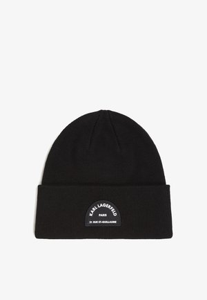 Black knit beanie featuring a folded cuff and a textured finish. A round, black patch with "Karl Lagerfeld Paris" and address details is centered.