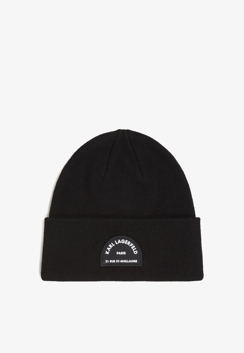 Mustavillinen neulepipo, jossa on taitettu reunus ja teksturoitu pinta. Keskellä on pyöreä musta patch, jossa lukee "Karl Lagerfeld Paris" ja osoitetiedot.