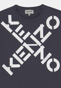 Námořnické bavlněné tričko s velkým bílým geometrickým textem a designem loga. Kulatý výstřih a krátké rukávy, hladká textura.