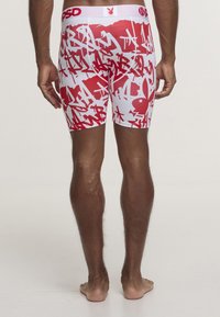 Calzoncillos bóxer rojos y blancos con un patrón de estilo grafiti, fabricados con un material suave y elástico y una cintura sólida.