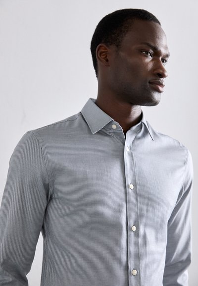 Men's long-sleeve shirt in light blue with a small check pattern, button-down collar, and white buttons along the placket.