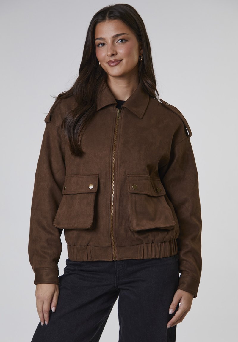 Brązowa kurtka bomber wykonana z syntetycznego zamszu, z zapięciem na zamek, naszytymi naramiennikami, dwiema przednimi kieszeniami i elastycznym pasem. Gładka tekstura.