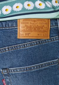 Levi's denimjeans med en brun läderetikett med präglade detaljer, ljusblått tyg och en klassisk femfickdesign.