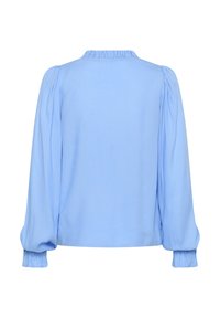 Blouse bleu clair en tissu lisse, présentant un col froncé, de longues manches bouffantes et des poignets élastiques. Vue de dos.