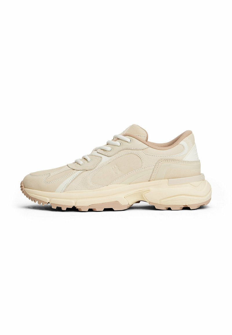 Baskets beige clair avec un empiècement en cuir texturé, bout rond, accents de panneaux contrastants et une semelle en caoutchouc épaisse avec un motif de semelle.