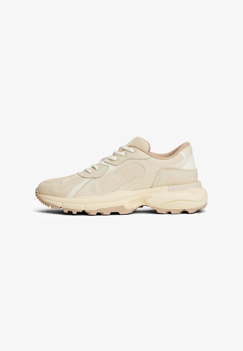 Baskets beige clair avec un empiècement en cuir texturé, bout rond, accents de panneaux contrastants et une semelle en caoutchouc épaisse avec un motif de semelle.