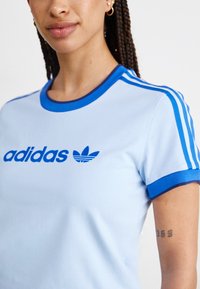 adidas Originals GRAPHIC BADGE SLIM 3-STRIPES - Triko s potiskem - clear sky