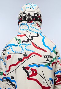 Weiße Jacke mit einem bunten Kartenmuster, das rote, blaue, grüne und schwarze Linien enthält; umfasst grafische Elemente und numerische Details.