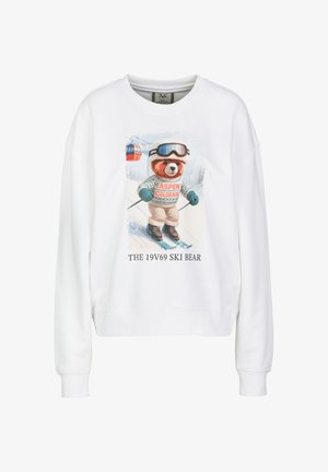 Witte trui met een afbeelding van een beer die aan het skiën is, met een skibril en een trui met de tekst Aspen Colorado, met de tekst hieronder The 19V69 Ski Bear.