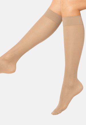 Beżowe pończochy do kolan wykonane z gładkiego, przejrzystego materiału z miękką, elastyczną opaską u góry zapewniającą pewne dopasowanie.