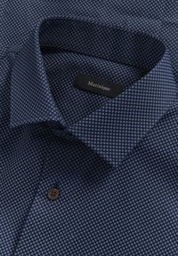 Camicia blu navy con un fine motivo circolare, caratterizzata da un colletto a punta, un singolo bottone marrone e un'etichetta che recita "Matinique."
