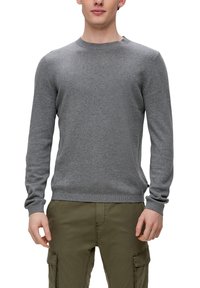 Pull à col rond gris en tissu doux, doté de manches longues, de poignets côtelés et d'une texture lisse. Associé à un pantalon cargo olive.