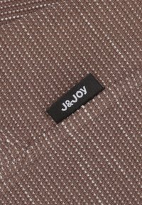 Bruin gebreid stof met een gestructureerd patroon. Voorzien van een zwart etiket met witte letters met de tekst "J&JOY."