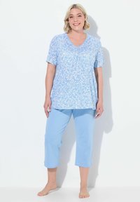 Top de manga corta con patrón floral azul y escote en V, combinado con pantalones capri azul claro. Tejido suave y corte relajado.