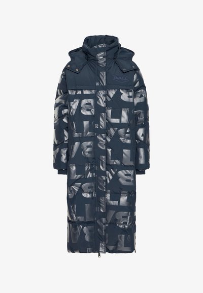 Polsterēts tumši zils parka ar augstu apkakli, kas rotāts ar lieliem atstarojošiem baltiem burtiem visā virsmā, ar ribotiem aproču galiem. Priekšpusē rāvējslēdzējs ar sprauļiem.