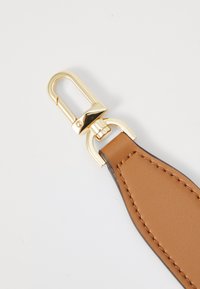 Brown leather strap with gold metal hardware, featuring a clip and detailed stitching along the edge. Smooth texture.