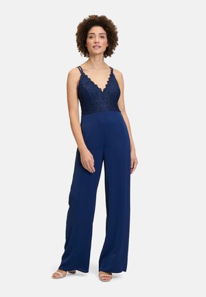 Navyblaues Jumpsuit mit einem Spitzenoberteil und einem gewellten V-Ausschnitt. Verfügt über verstellbare Träger und ein weites Bein-Design. Glatte Stoffstruktur.