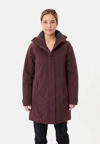 Bordeauxrode lange jas met ritssluiting en drukknopen, grijze capuchon gevoerd met fleece, twee zijzakken en een gladde, matte afwerking.