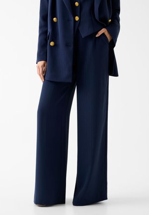 - Spodnie materiałowe