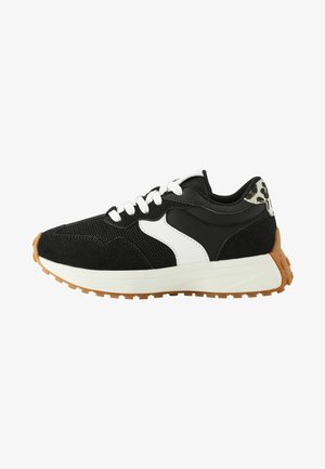 Zapatilla deportiva negra con acentos en blanco y estampado de leopardo, materiales de malla y gamuza, cordones blancos y suela de goma.