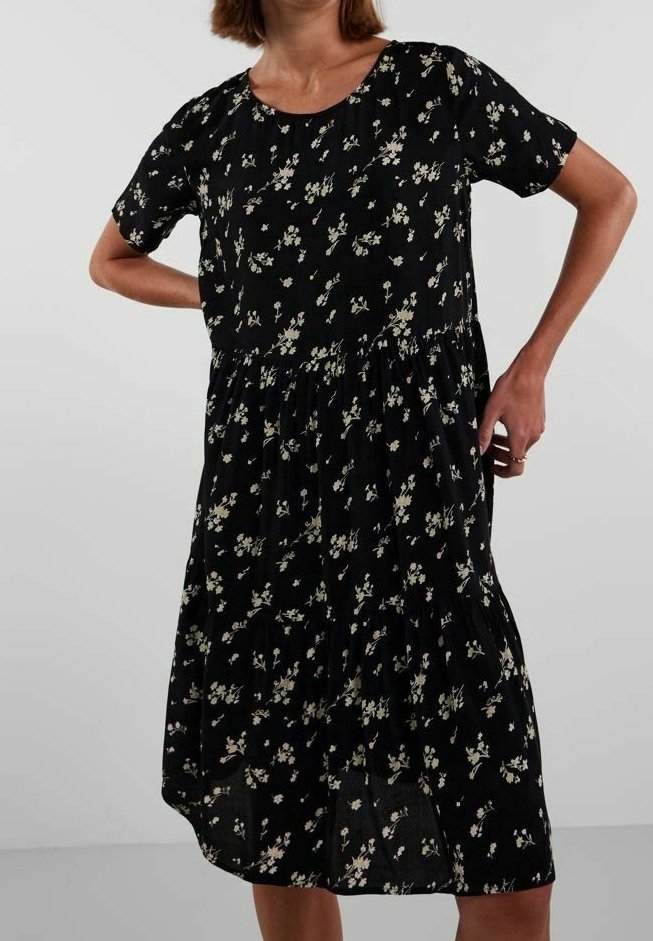 Černé květinové šaty s krátkými rukávy, kulatým výstřihem a nařasenou sukní. Obsahují malý bílý květinový vzor a lehkou texturu materiálu.