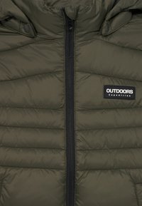 Olivgrüne Steppjacke mit Kapuze, ausgestattet mit schwarzem Reißverschluss und einem Patch-Logo. Strukturierter, genähter Entwurf mit seitlichen Taschen.