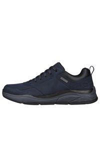 Scarpe sportive blu navy con un esterno in suede liscio, dettagli neri, una suola imbottita e lacci stilizzati. Design leggero e traspirante.