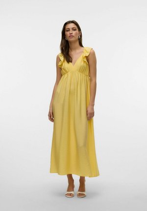 Vestido maxi amarillo con escote en V, tirantes con volantes y una silueta fluida. Tejido suave y liviano con una textura sutil.