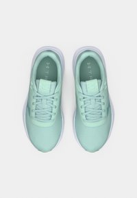 Ζευγάρι αθλητικά παπούτσια σε φωτεινό μέντα πράσινο χρώμα με λευκές σόλες στη μέση, δεμένα κορδόνια, σε θέα από πάνω σε λευκό φόντο.