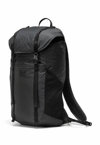 Sac à dos noir avec un motif en grille, bretelles rembourrées, fermeture à rabat supérieur et détails en maille latérale. Fabriqué en nylon durable.