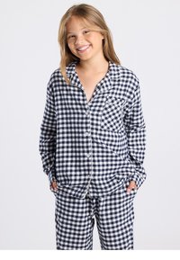 Ensemble de pyjama à carreaux bleu marine et blanc comprenant un haut à manches longues, une poche et une fermeture boutonnée à l'avant. Tissu doux avec une coupe décontractée et pantalon assorti.
