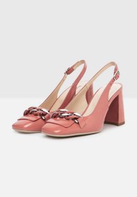 Pink patent leather slingback heels with a square toe and a chunky block heel. Features a silver chain accent on the front.