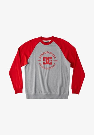 Szara bluza z czerwonymi raglanowymi rękawami, z czerwonym okrągłym logo na środku. Prążkowany dekolt i mankiety.