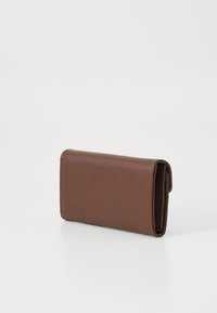 Portefeuille marron en matériau synthétique texturé, de forme rectangulaire, doté d'une fermeture à rabat et d'un détail de couture visible.